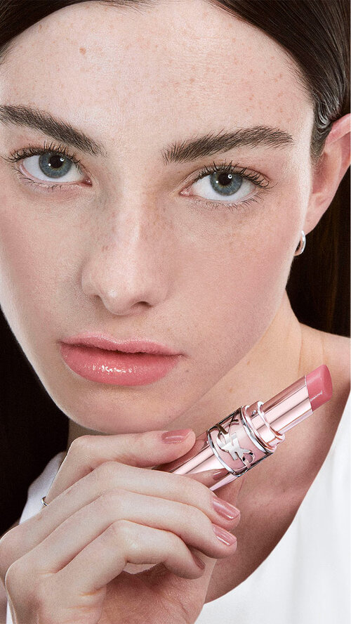 Chloe, radiant in YSL LOVESHINE Candy Glow 44b, product in hand, lips shimmering with a subtle, fresh allure.
