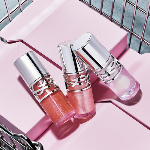 Three YSL Loveshine in shades 10, 11, and 12 displayed on purple blocks in a metallic basket.