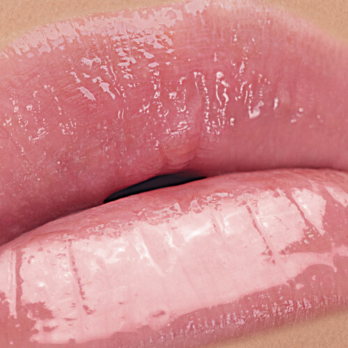 Close-up of lips wearing YSL LOVESHINE Candy Glow in shade 1B, showcasing a glossy, plump finish.