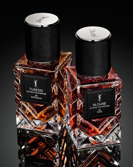 YSL Le Vestiaire des Parfums Tuxedo and Blouse Extrait de Parfum, faceted bottles with black caps, on a reflective black surface.