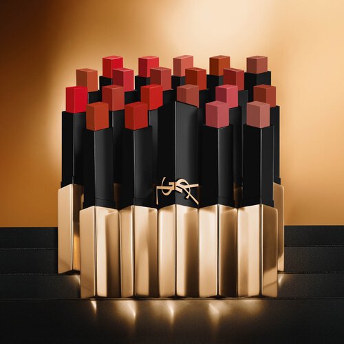 YSL Couture Matte Lipsticks in a range of red, brown, and pink shades, with black and gold packaging, on a golden background.