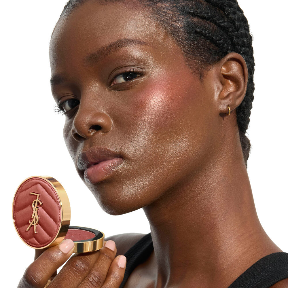 YSL Beauty model, with YSL LOVESHINE Plumping Lip Oil Gloss shade 10 near her deep-toned, shimmering lips.