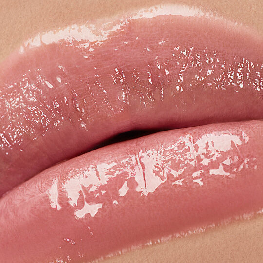 Close-up of lips wearing YSL LOVESHINE Lipstick in shade 44 Nude Lavaliere, showcasing a glossy, plump finish.