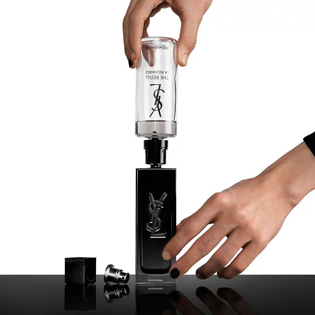Des mains remplissant un flacon de parfum MYSLF a l'aide d'une cartouche de recharge afin de reduire l'impact environnemental.