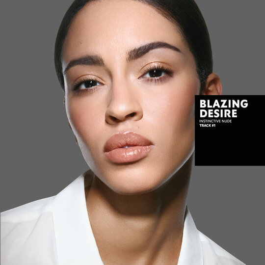 Karen, tanned skin tone, with an instinctive nude eye look and blazing desire glossy lips, wearing a white top.