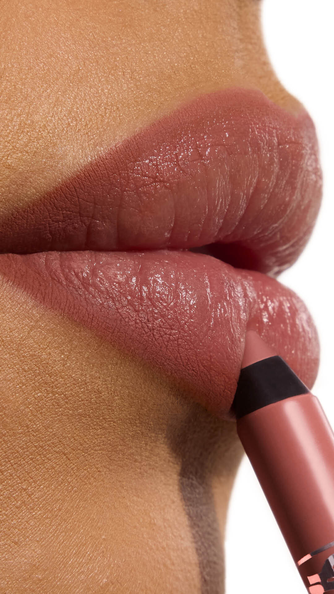 Ehlana applying YSL LOVENUDE Kiss Shaper 26 in Shade 103, a close- up of her lips.