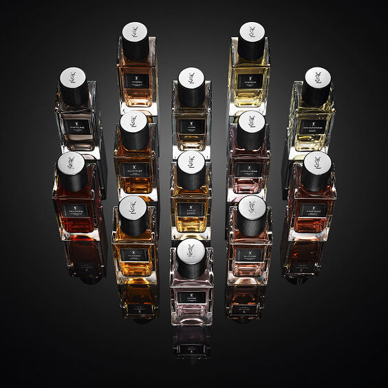 Top view of YSL Le Vestiaire Des Parfums Collection Essentielle, luxury fragrance flacons with black caps and YSL logo on black.