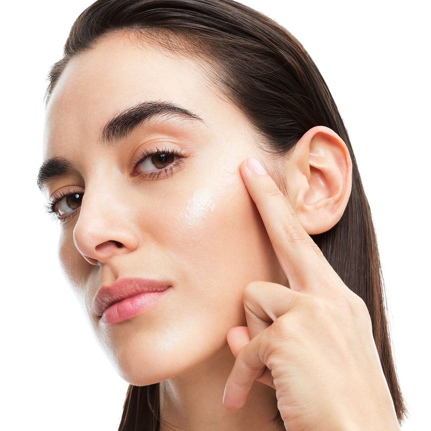 Alicia, YSL Beauty model, applying YSL Pure Shots Stability Reboot to her cheek, highlighting skin's natural glow.