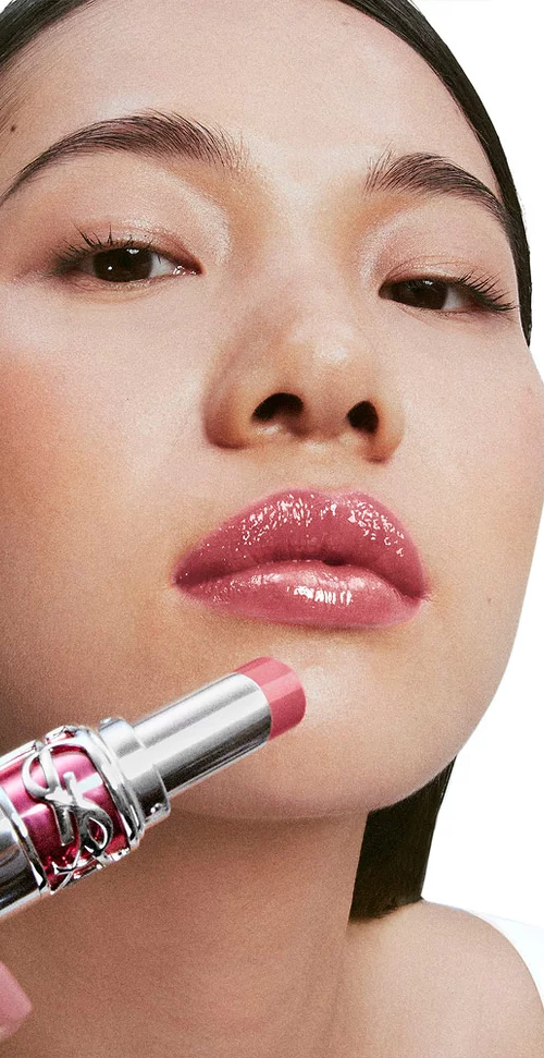 Model Jiangyue, fair skin tone, applying YSL Loveshine Candy Glaze in shade 44 Nude Lavalliere to her glossy lips.