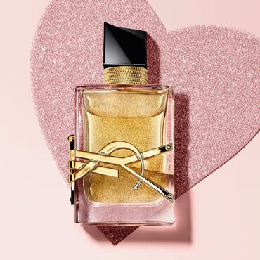 YSL Libre Eau de Parfum, a gold-toned bottle with the YSL logo, on a glittery heart background.