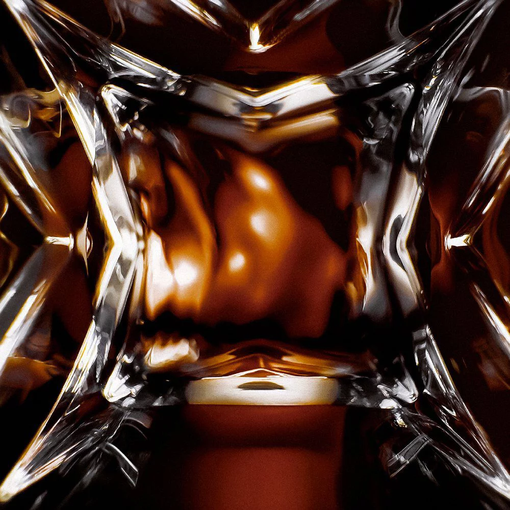 YSL LVDP Tuxedo Extrait de Parfum bottle, extreme close-up of the intricate glass design with luminous reflections.