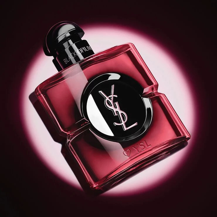 Close-up of the pink lacquered Black Opium Eau de Parfum Pink Glaze bottle with a heart and YSL engraving at the base.