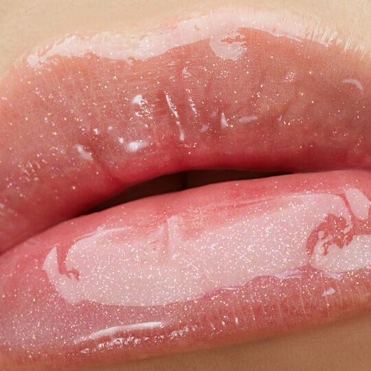 Close-up of lips wearing YSL LOVESHINE Plumping Gloss in shade 1, with a shimmering, high-shine finish.