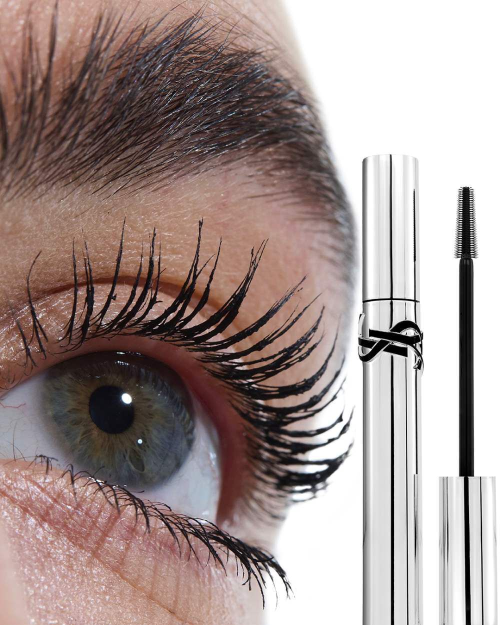 Close-up of an eye with YSL Lash Latex Mascara applied, alongside the silver mascara tube, on a light skin tone.