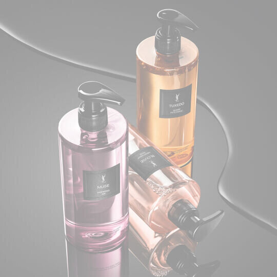 YSL LVDP Hand & Body Wash range: Muse, Tuxedo, and Blouse bottles on a sleek, reflective black surface.