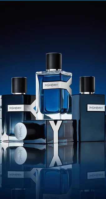 A collection of YSL Y fragrances, showcasing various blue bottles with iconic Y logos, arranged elegantly on a reflective surface.
