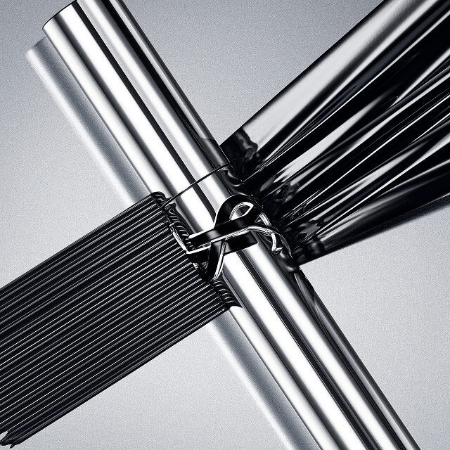 YSL Lash Latex Mascara in sleek silver packaging, showcasing rich black texture on a reflective grey background.