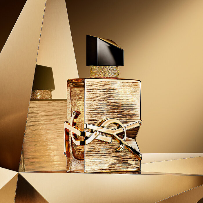Libre Vanille Couture Eau de Parfum bottle displayed on a reflective golden background.