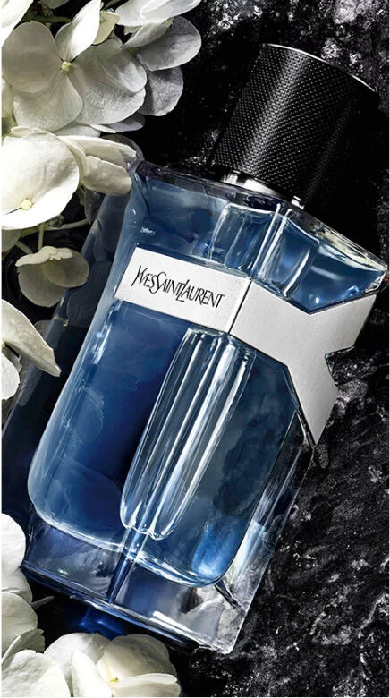 YSL Y Eau de Toilette bottle, with elegant white flowers and a dark, luxurious textured background.