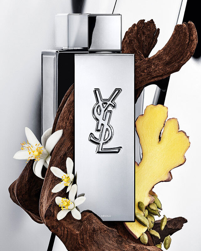 MYSLF L'Absolu fragrance bottle by YSL Beauty surrounded by ginger root, orange blossom and woods.