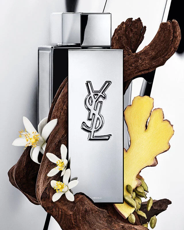 MYSLF L'Absolu fragrance bottle by YSL Beauty surrounded by ginger root, orange blossom and woods.
