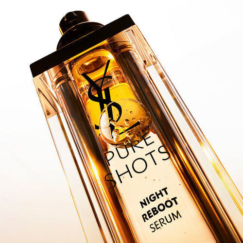 Close-up of YSL Pure Shots Night Reboot Serum, showcasing its luxurious golden texture and iconic YSL Cassandre logo.