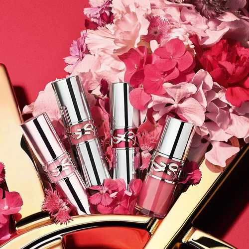 YSL Loveshine collection on a glossy gold YSL logo, with vibrant pink flowers, against a pink background.