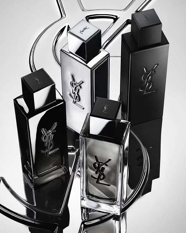 Group shot of the complete MYSLF fragrance range bottles standing on a large YSL Cassandre logo with a reflective mirror effect.