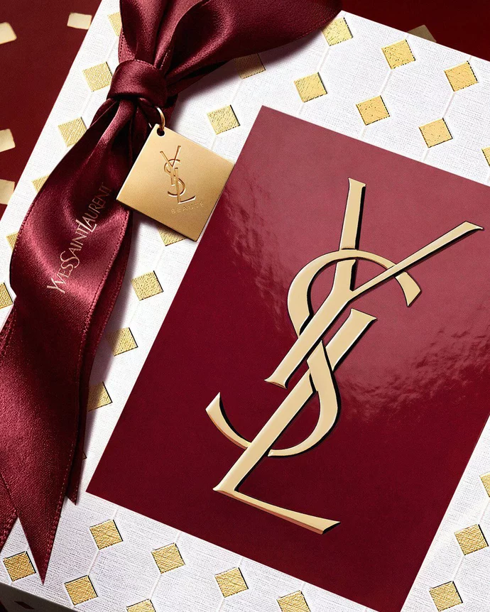 Couture burgundy YSL Holiday gift box tied with a luxurious ribbon and embossed gold logo.