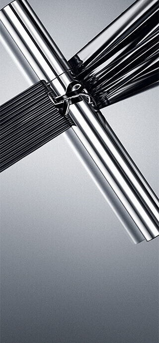 YSL Lash Latex Mascara in sleek silver packaging, showcasing rich black texture on a reflective grey background.
