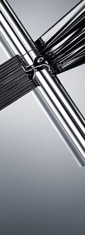 YSL Lash Latex Mascara in sleek silver packaging, showcasing rich black texture on a reflective grey background.