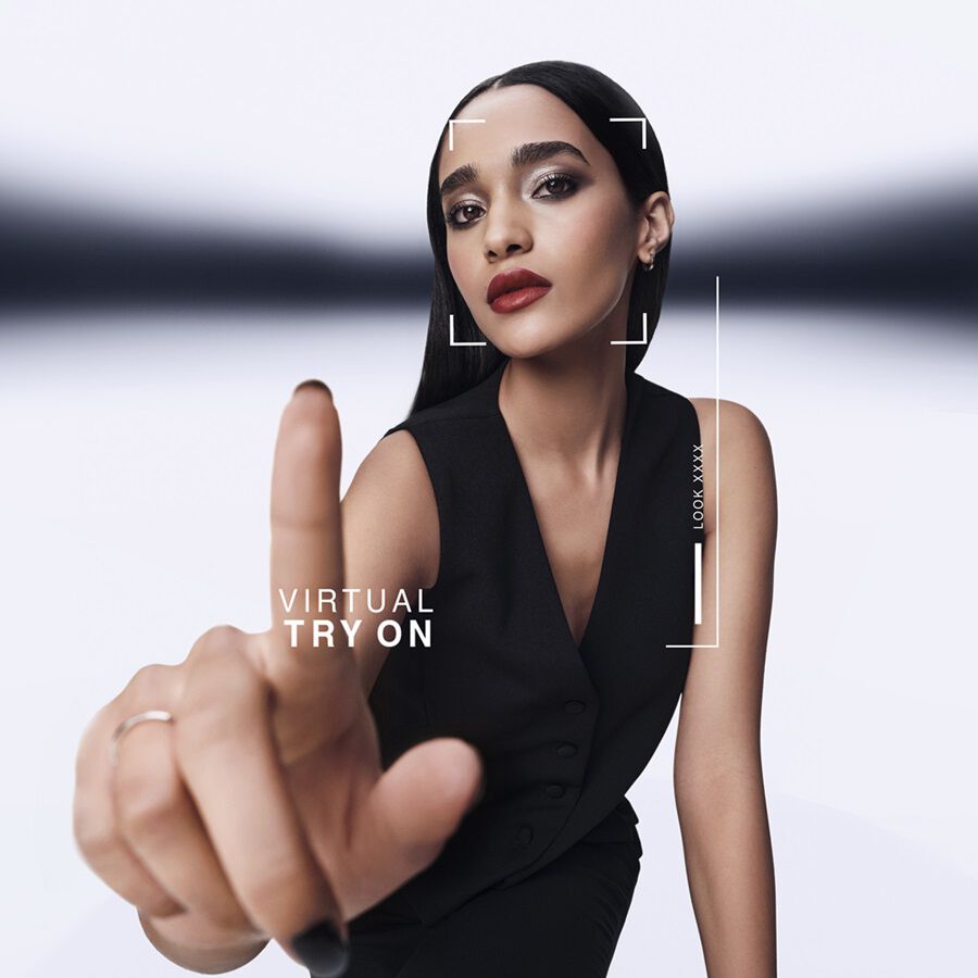 Model with sleek black hair and nails engaging with YSL&apos;s Virtual Try-On interface, modern and interactive.