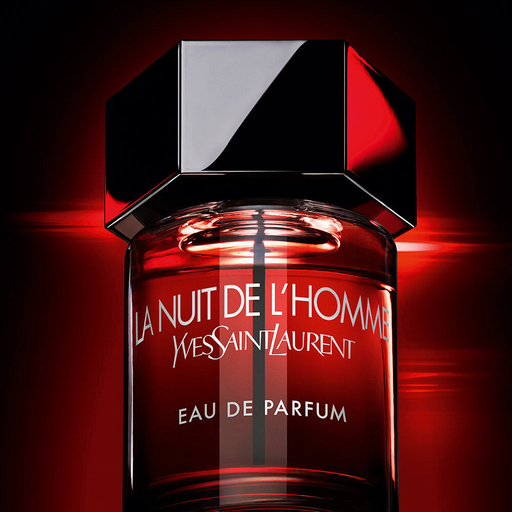 A cinematic, backlit shot of the bottle glowing with an intense red light against a dark background, evoking a sense of mystery and "incandescent" sensuality.