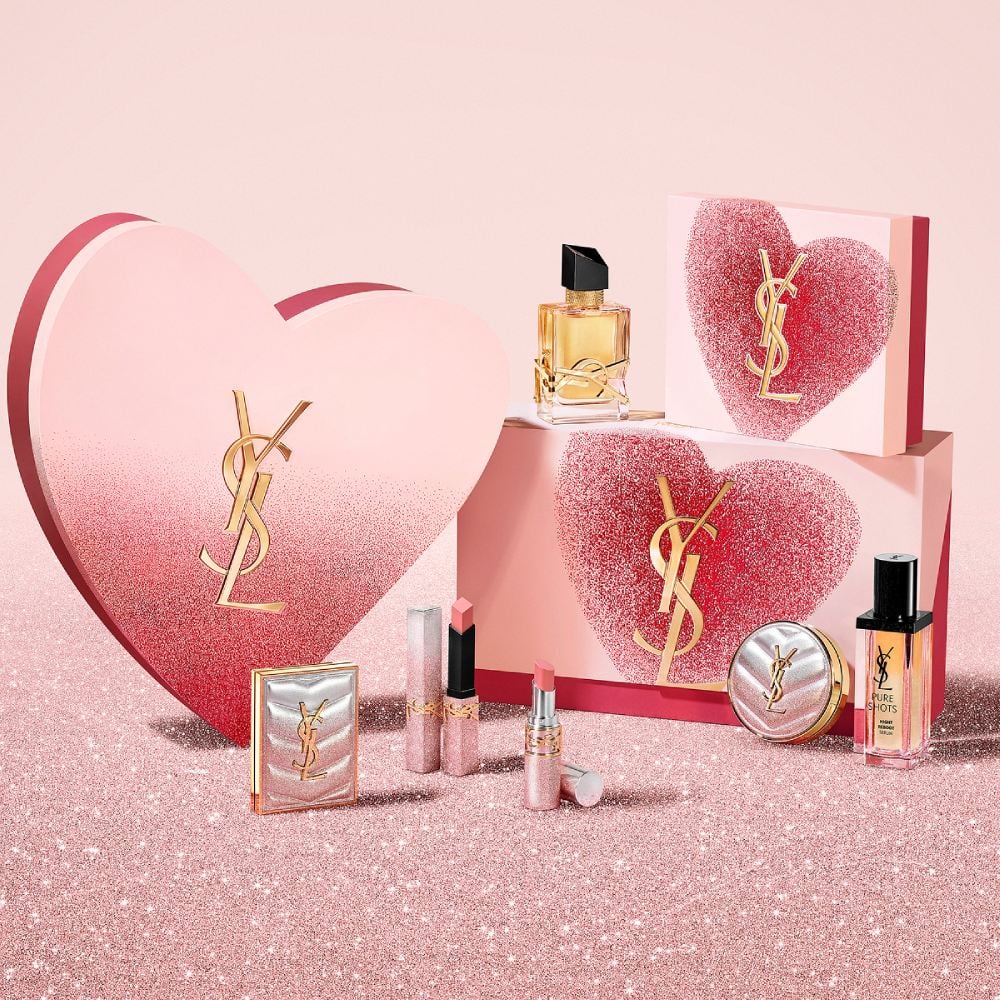 YSL Beauty Valentine's Day sets and products,
including LIBRE Eau de parfum, makeup and
skincare, on a red glitter surface.