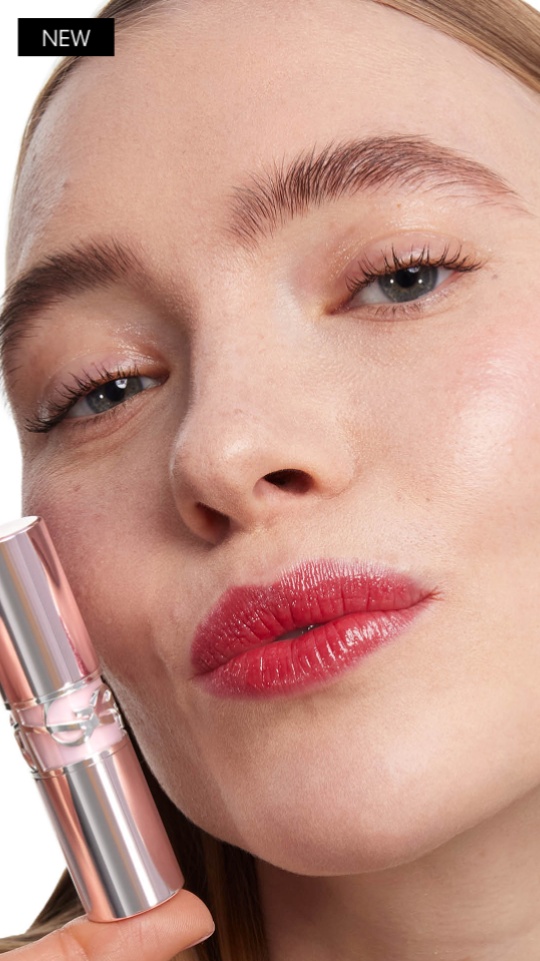 Model holding YSL LOVESHINE CANDY GLOW lip balm showcasing glossy tinted lips.