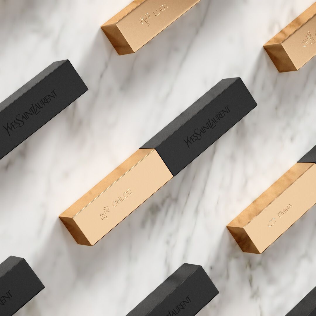 YSL The Slim lipsticks, black and gold, personalized with names like 'Chloe' and 'Lucy', arranged on a white marble surface.