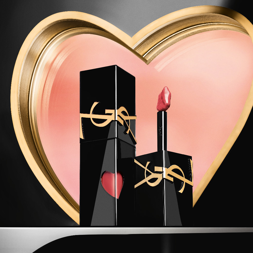 YSL lipsticks displayed in front of a golden heart sculpture.