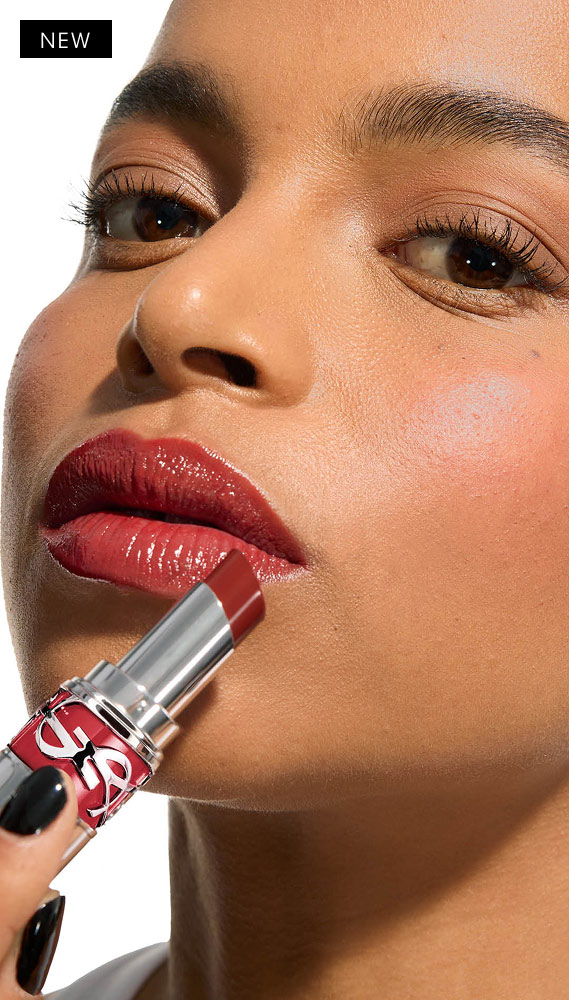 Model Mawena applies YSL LOVESHINE Lipstick in Berry Crush, shade 219, to her glossy lips.