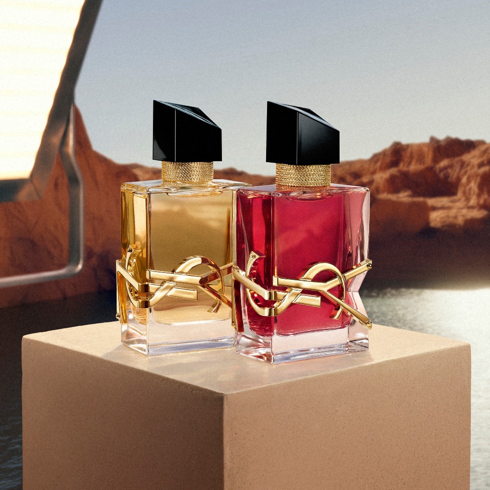YSL LIBRE EDP, and LIBRE BERRY CRUSH perfumes on a pedestal with studio light in a desert landscape.