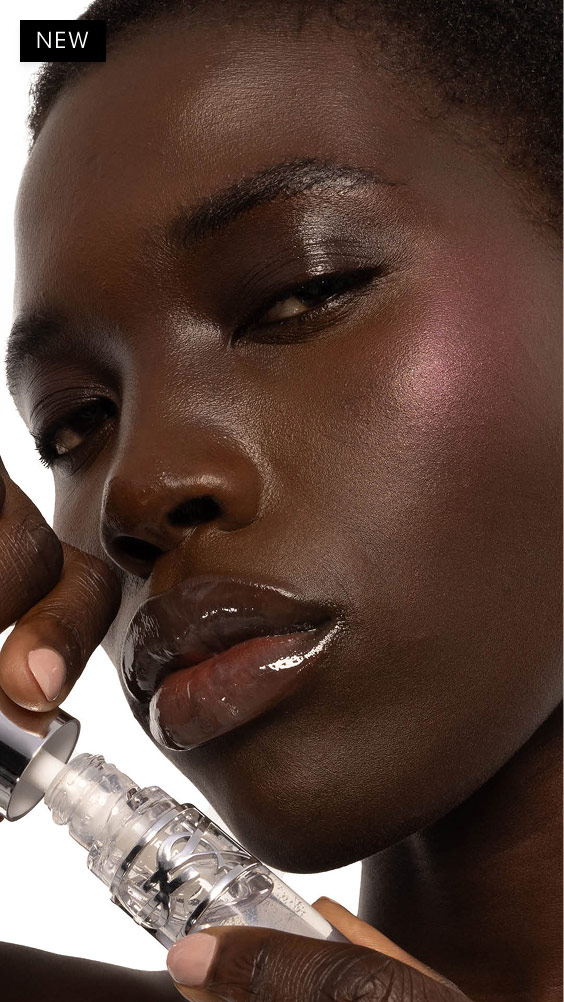 Nyaluak, deep-skinned, with YSL LOVESHINE Plumping Lip Oil Gloss in Shade 11 Radiant Glass, showcasing glossy lips.