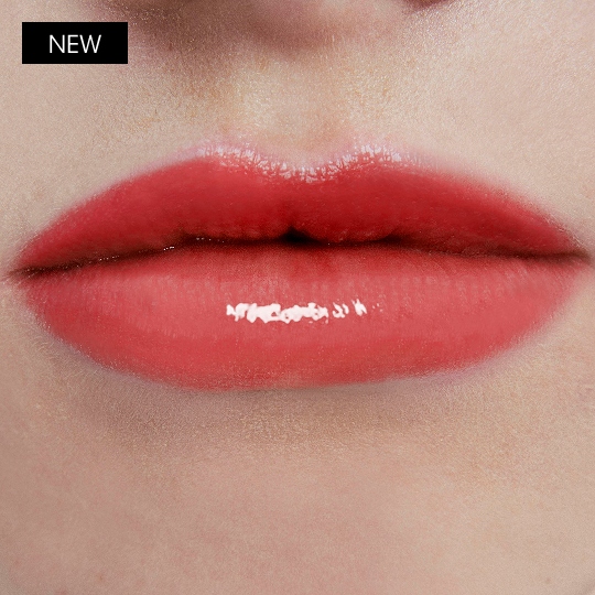 YSL LOVESHINE CANDY GLOW lip balm shade Sweet Tangerine worn on lips with luminous shine.