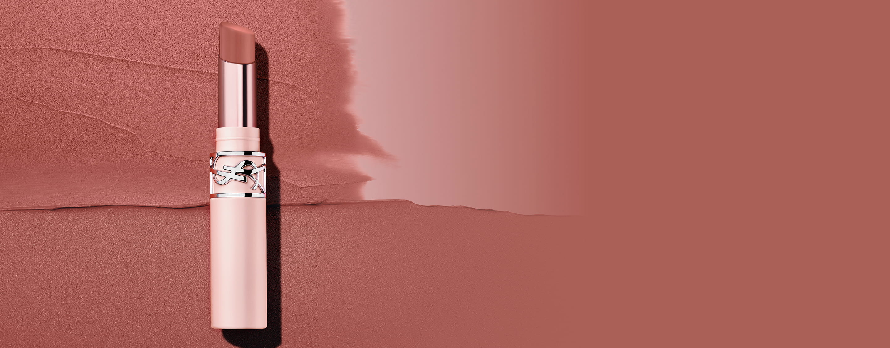 YSL LOVENUDE Lip Blusher in shade 44, standing on a textured background of two complementary nude shades.