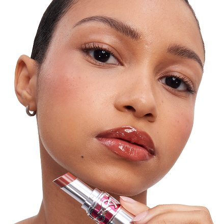 Model applying YSL LOVESHINE CANDY GLAZE lip gloss with luminous finish.