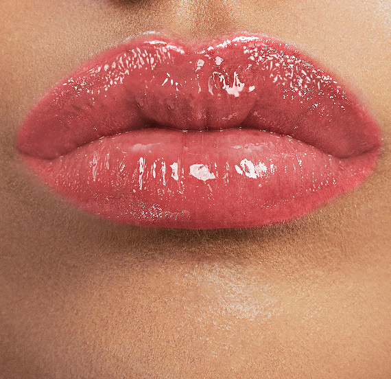 Lips wearing YSL LOVESHINE CANDY GLAZE shade Watermelon High with juicy gloss.