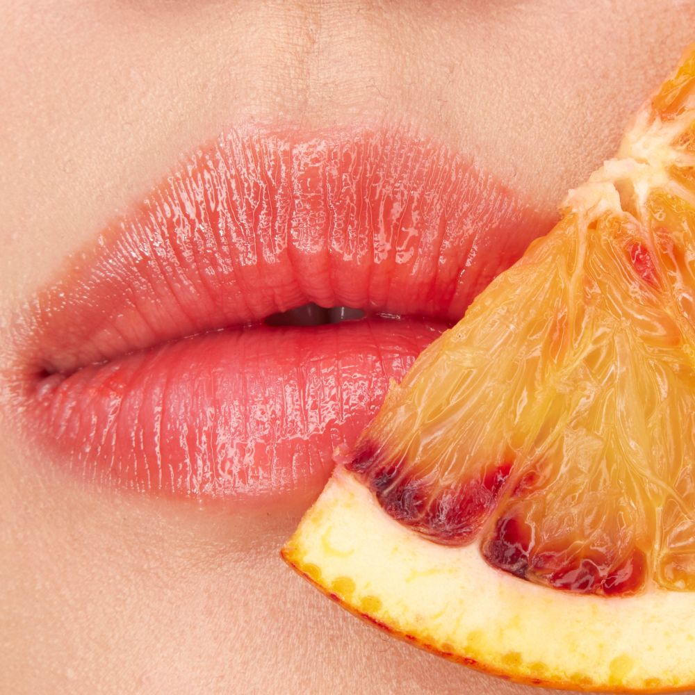 Close-up lips wearing YSL LOVESHINE CANDY GLOW lip balm with juicy shine.