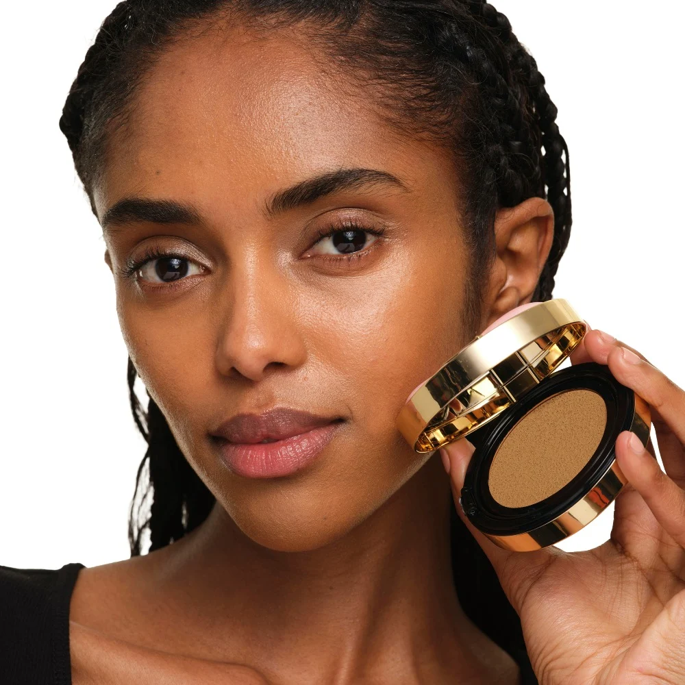 Model with medium skin holding YSL SKIN AFFAIR SOFT GLOW CUSHION. Radiant, unified and natural-looking complexion.