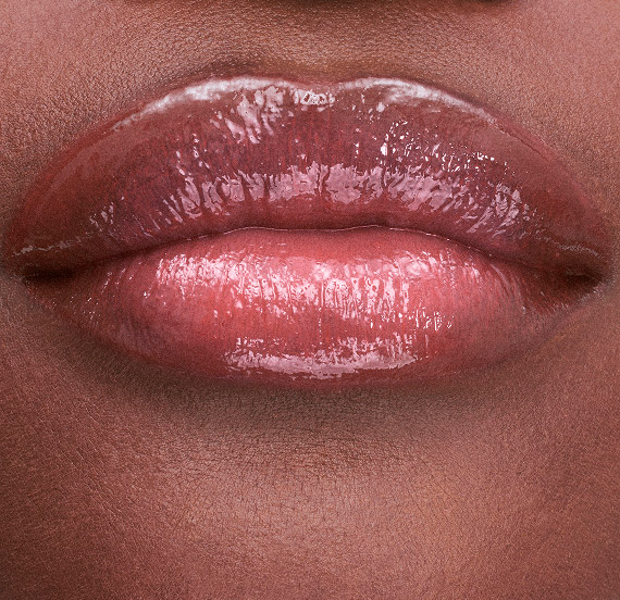 Lips wearing YSL LOVESHINE CANDY GLAZE shade Nude Lavallière with luminous finish.