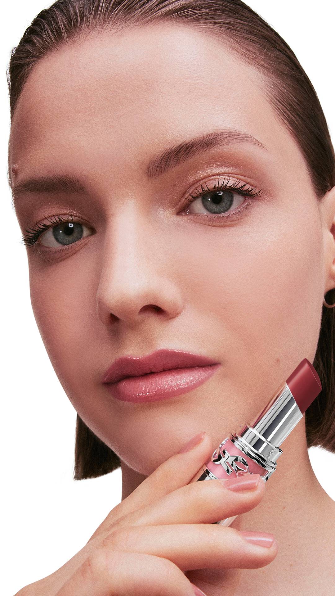 Tess, fair skin, holds YSL LOVESHINE Lipstick shade 154 near her
glossy berry-pink lips.