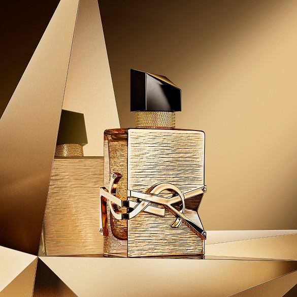 Libre Vanille Couture Eau de Parfum bottle displayed on a reflective golden background.