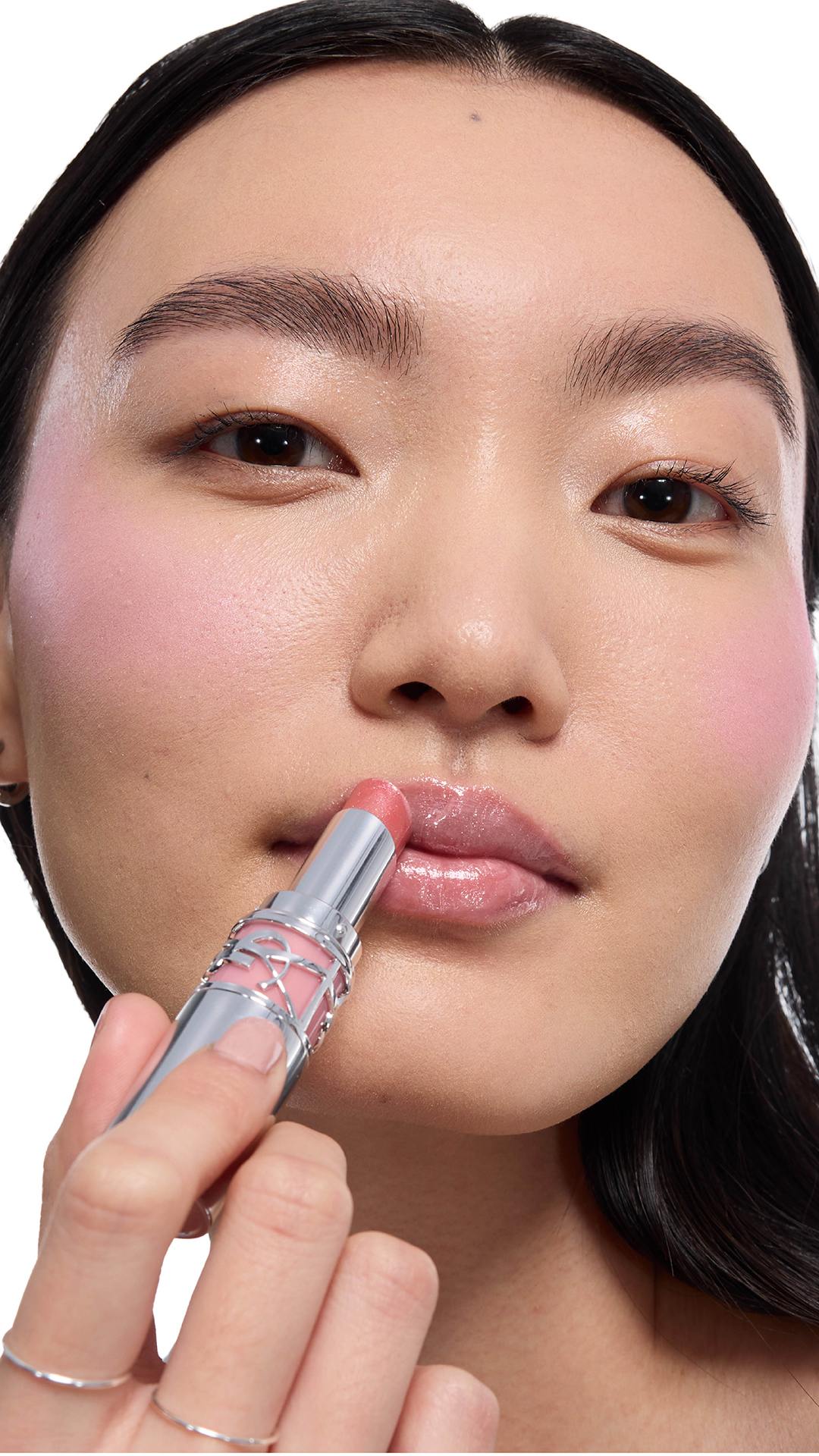 Jia Lu Yi, light skin, applies YSL LOVESHINE Lipstick shade 10. Cheeks
show blush.